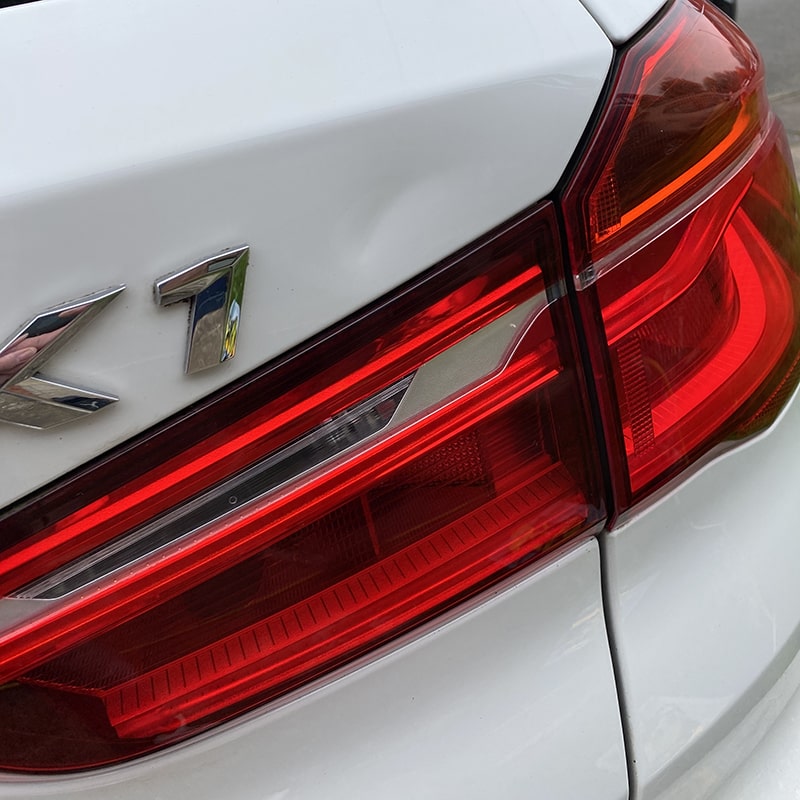 White BMW with Dent on boot